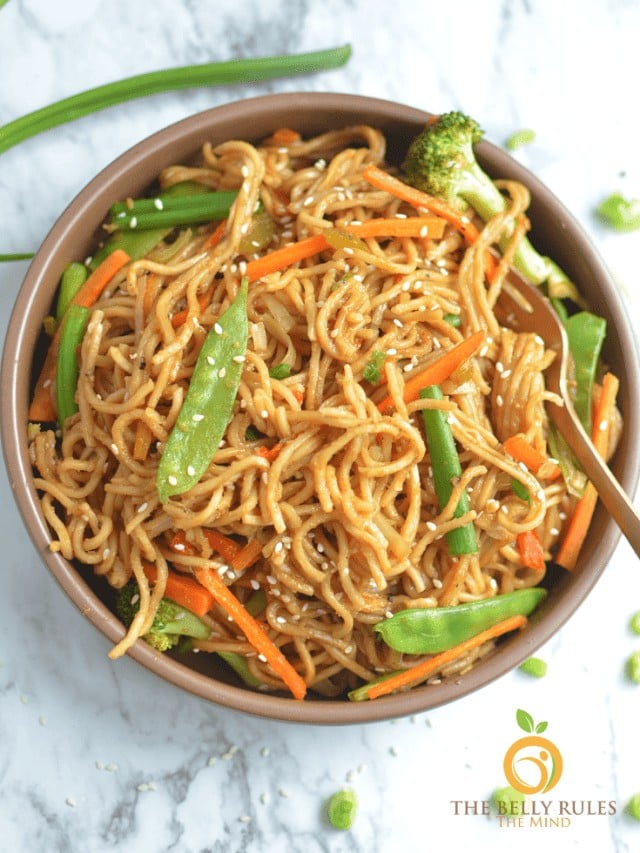 Delicious stir-fried noodles with broccoli, carrots, and green beans in a bowl.