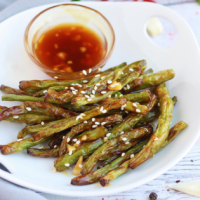 A plate of Air Fryer Green Beans and Chili Garlic Sauce