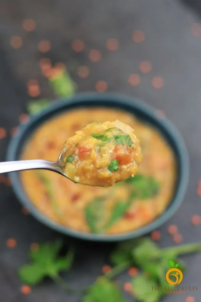 a spoonful of red lentil soup with lemon