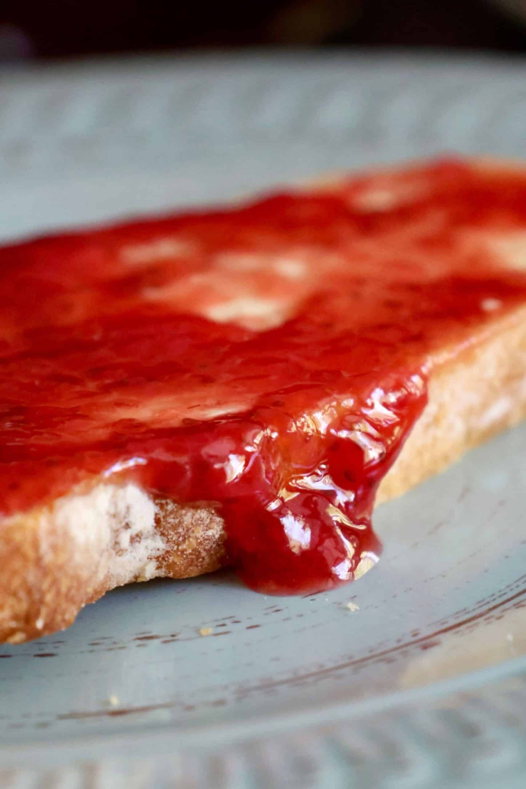 Close-up of homemade strawberry jam spread on toasted bread.