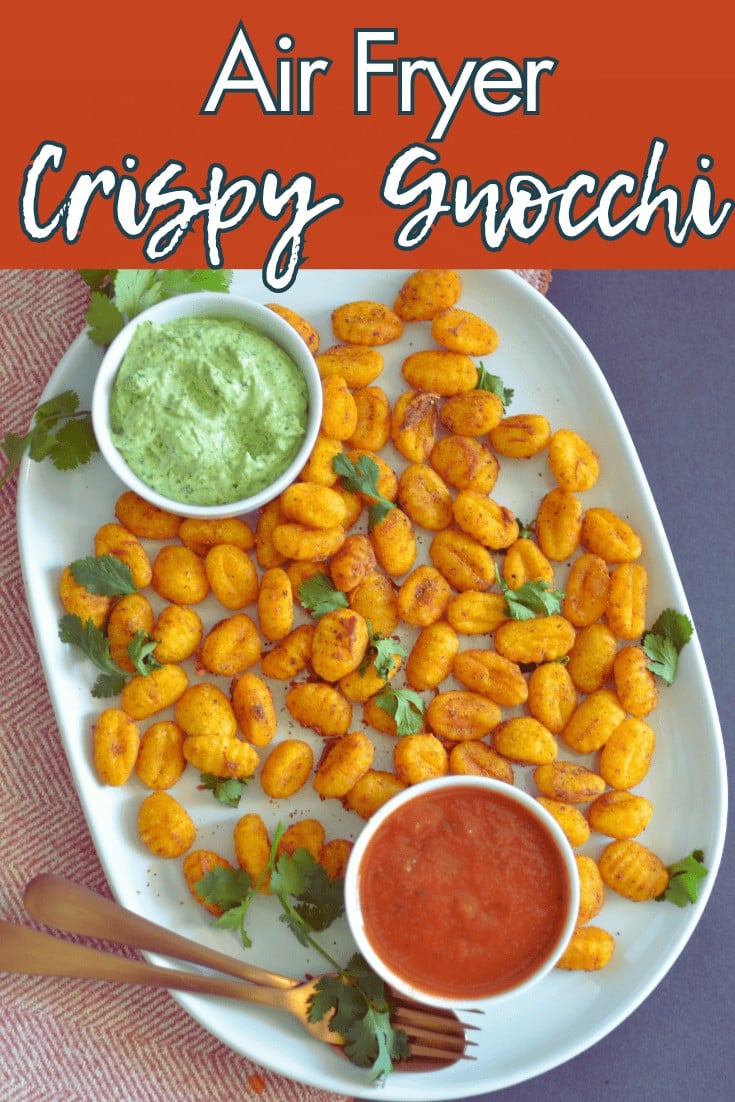 Crispy air fryer gnocchi served with green herb dip and red tomato sauce on a white platter.