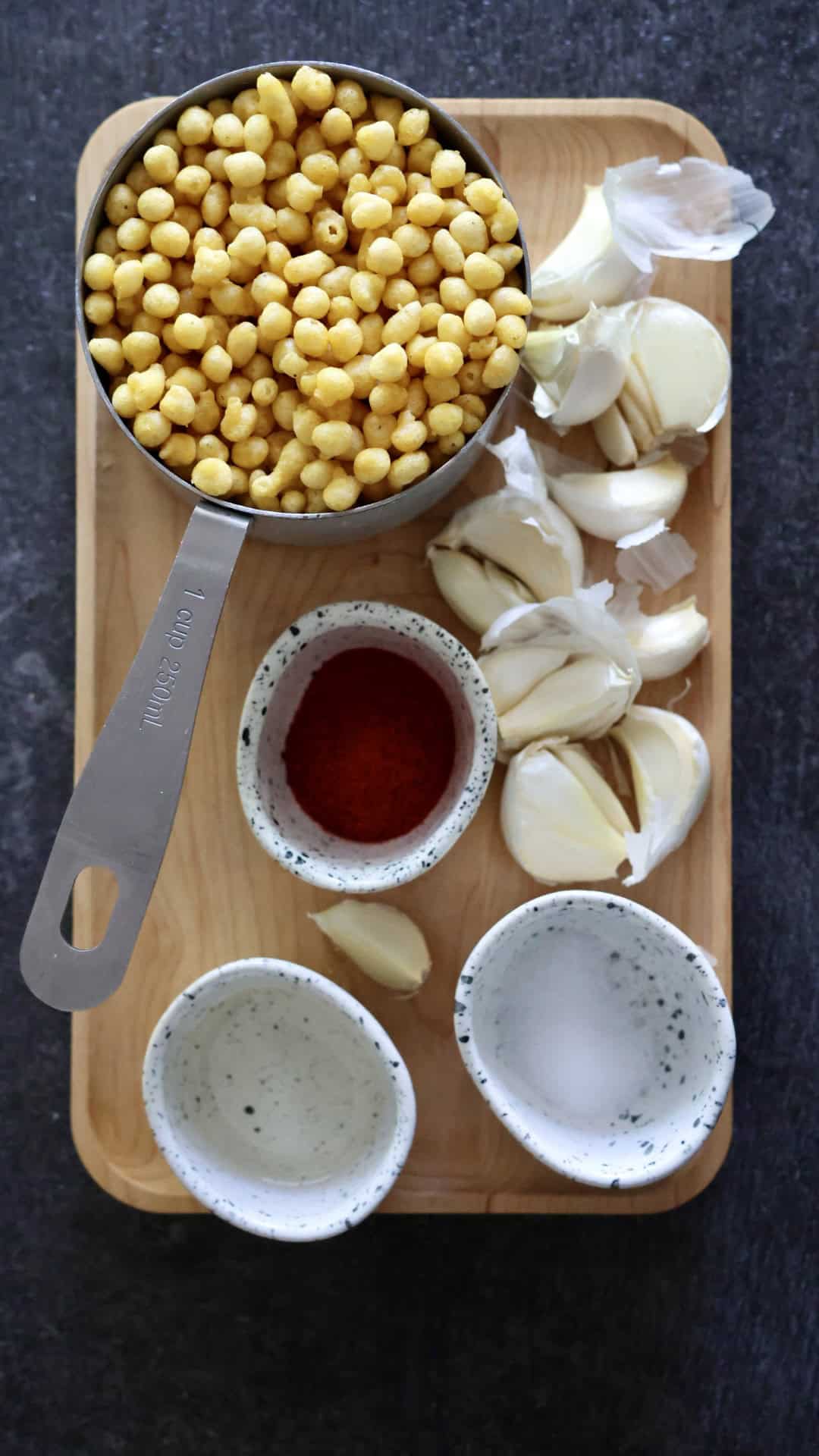 Crunchy chickpeas with garlic and spices on a wooden tray, healthy snack option.