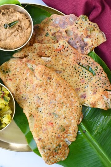 Delicious crispy Rava Dosa with a lacy texture, perfect for breakfast or snack, served with chutneys.
