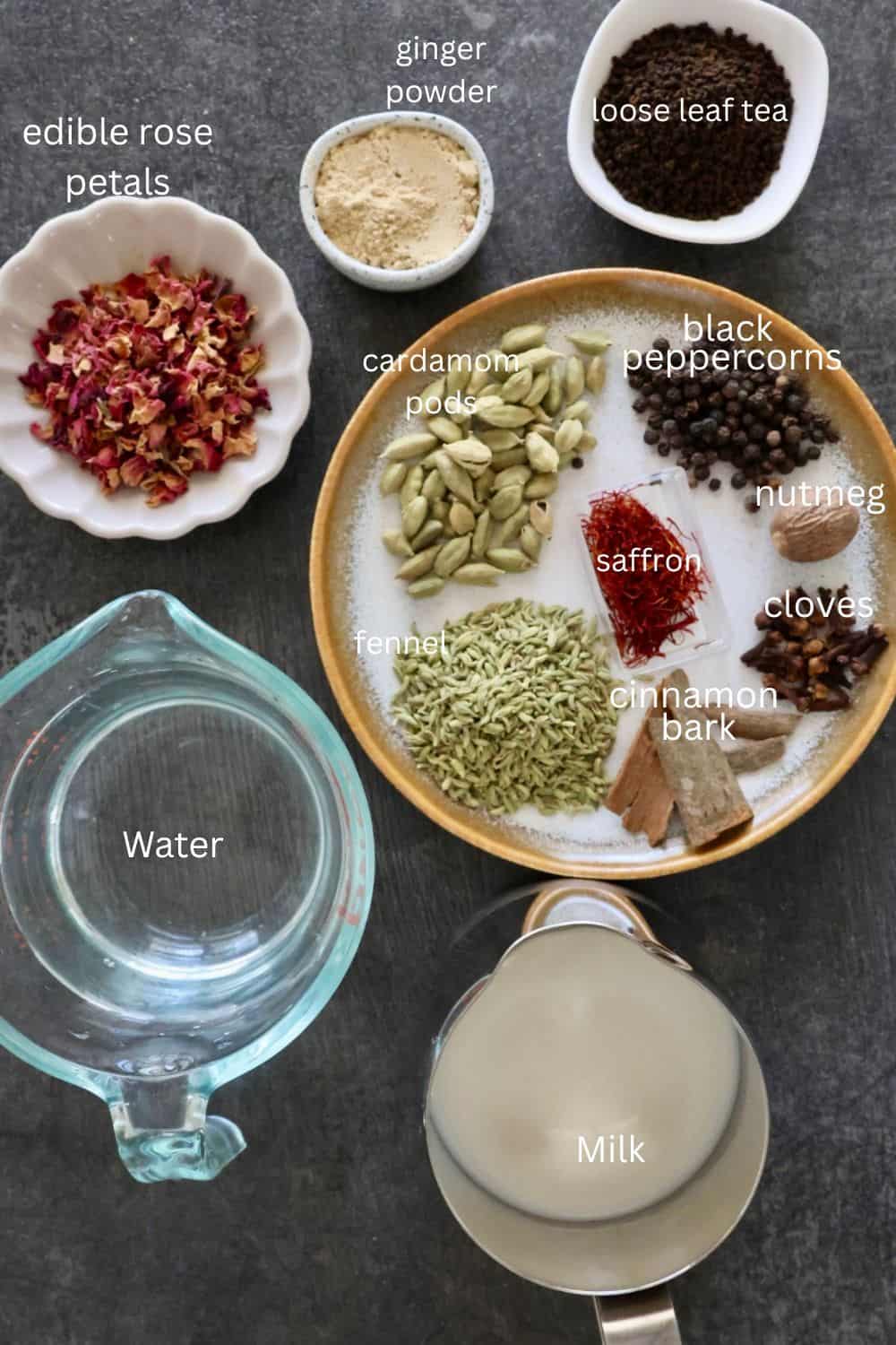 Assorted spices for masala chai including cardamom, cinnamon, ginger, and black peppercorns.