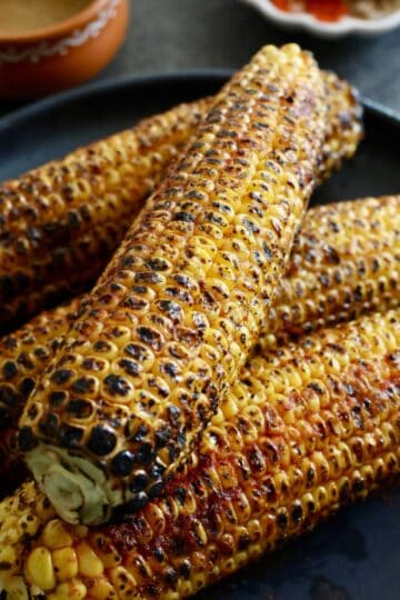 Indian-style roasted corn on the cob with spices and charred grill marks.