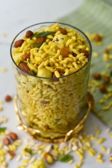 Masala murmura chivda in an air fryer basket, showing spiced puffed rice mixed with peanuts, chana dal, and curry leaves, lightly roasted and crispy.