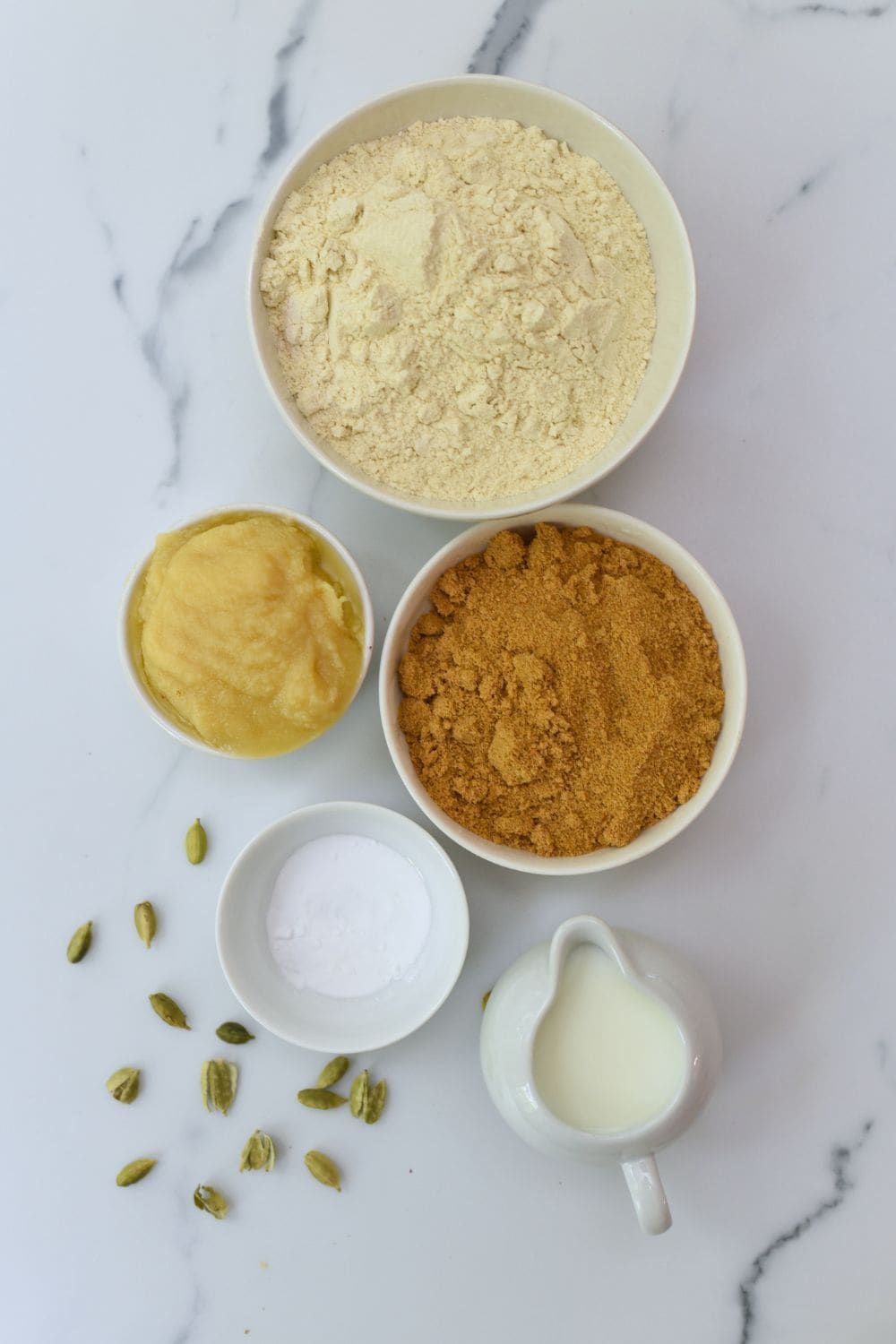 Ingredients for Punjabi Atta Biscuits including flour, sugar, ghee, and cardamom.