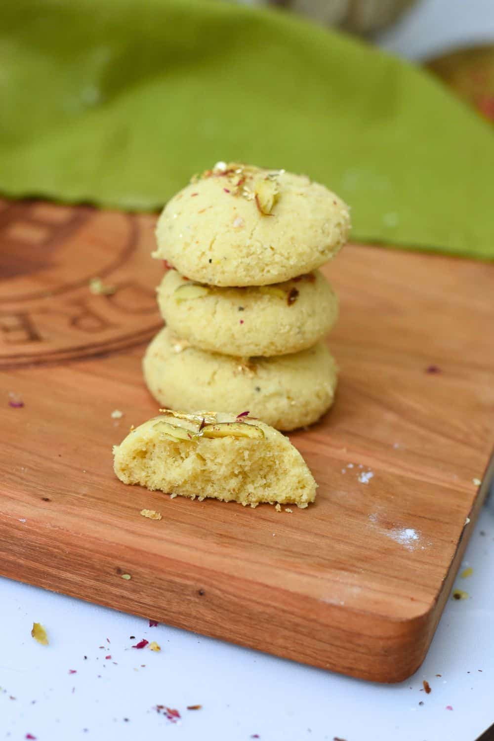 Stack of eggless Indian Nankhatai cookies on wooden board.